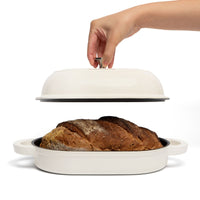 Domed lid held above a baked loaf in the oval bread oven
