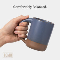 Harbor Blue stoneware mug held in one hand, showing the full-hand handle