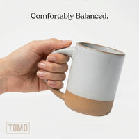 Dove Grey stoneware mug held in one hand, showing the full-hand handle