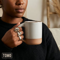 Person in a black top holding a Dove Grey TOMO mug